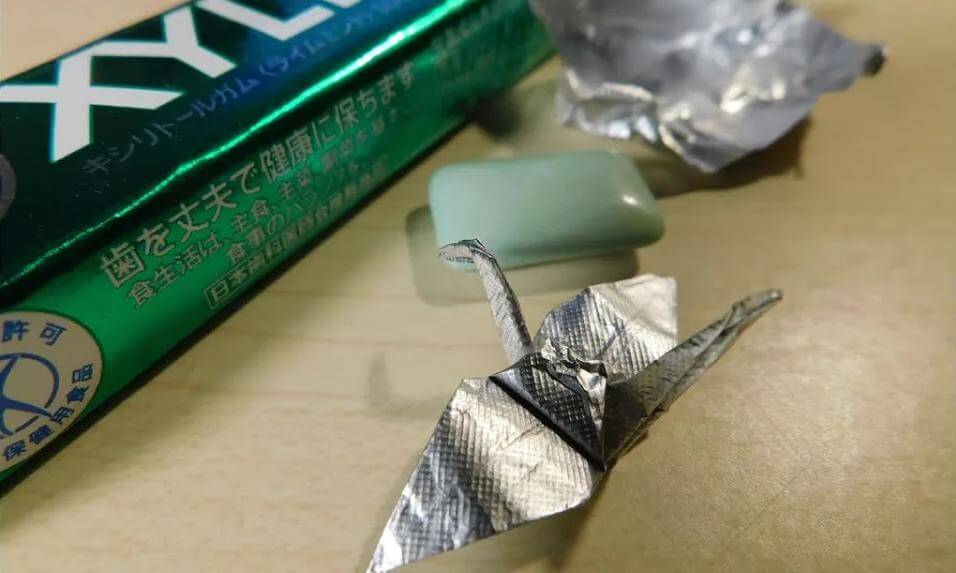 Small crane by folding origami with a gum wrapper.