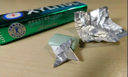 Small shuriken(ninja star) by folding origami with a gum wrapper.