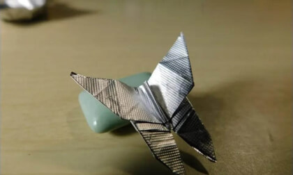 Small butterfly by folding origami with a gum wrapper.