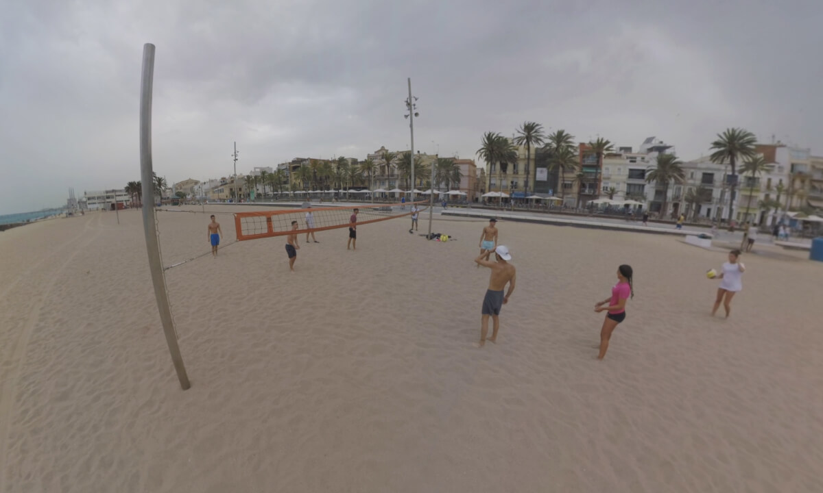 360 VR View of Barcelona coast with houses alongside and people playing volleyball, Spain