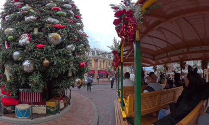 44. Walking in under the Disneyland entrance sign, to a horse drawn rail car on Main Street, around Partners to the Magic Castle then around 70th sign through the Magic Castle to the carousel (ends near 'film' camera guy, great one!)