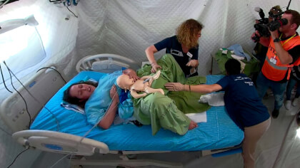 A woman giving birth to an alien baby in field hospital during National Earthquake/War Drill. Cheering in the background is Yitshak Kreiss MD, Director General, Sheba Medical Center, Tel Hashomer. After that the baby sleeps in an incubator 360VR. A woman giving birth to an alien baby in field hospital during National Earthquake/War Drill. Cheering in the background is Yitshak Kreiss MD, Director General, Sheba Medical Center, Tel Hashomer. After that the baby sleeps in an incubator 360VR.