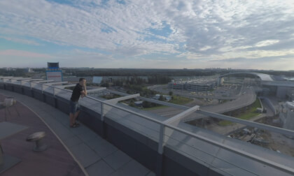 360 VR Man in rooftop cafe looking at airport and road traffic, Moscow