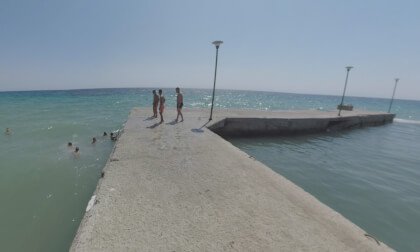 360 VR Seafront view and young men jumping into water from the pier