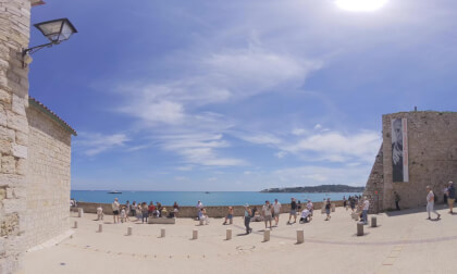 Antibes, France, Cote d´azur at the Picasso Museum, a Musician plays in front of the blue Sea, to the right the Cap de Antibes and in the background some Yachts VR Video Antibes, France, Cote d´azur at the Picasso Museum, a Musician plays in front of the blue Sea, to the right the Cap de Antibes and in the background some Yachts VR