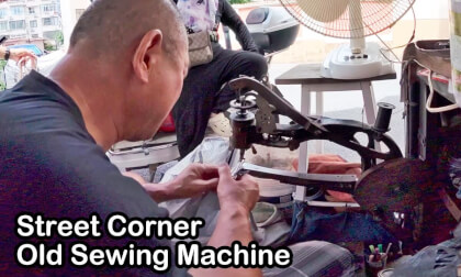 The old-fashioned hand-cranked sewing machine on the street corner The old-fashioned hand-cranked sewing machine on the street corner