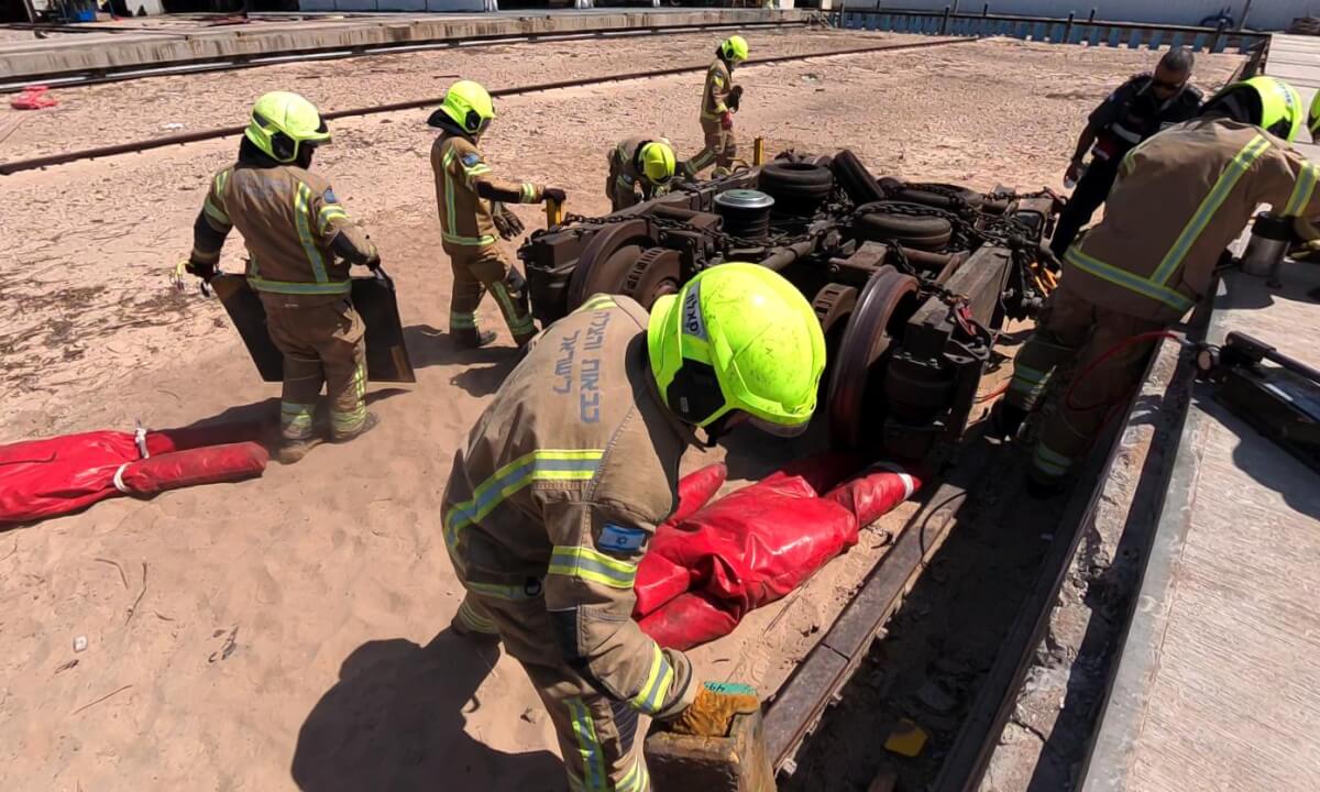Firefighters use hydraulic tools to rescue dolls in Haifa train drill