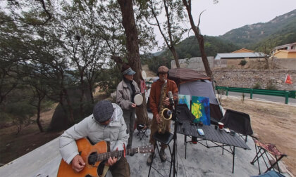 71-year-old street performer plays "Hometown" in Qingdao's Laoshan, China.