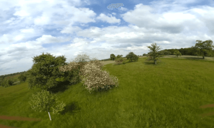 fpv drone flight over spring green fields and trees fpv drone flight over spring green fields and trees