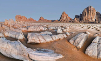Desert Landscape With Boulders And Rocky Mountains